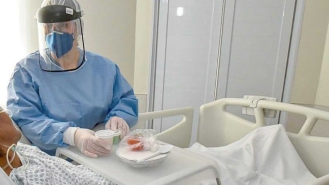 Enfermeira em leito de paciente