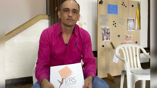 Homem com cartilha da empresa VRS Academy