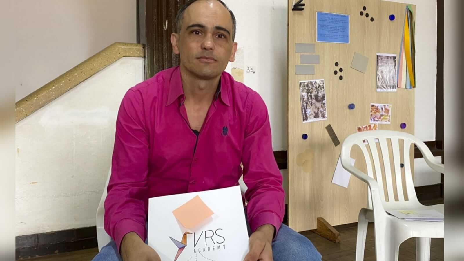 Homem com cartilha da empresa VRS Academy