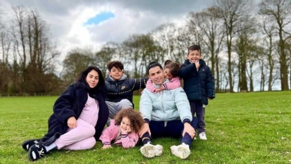 Cristiano Ronaldo com a família sentados em gramado