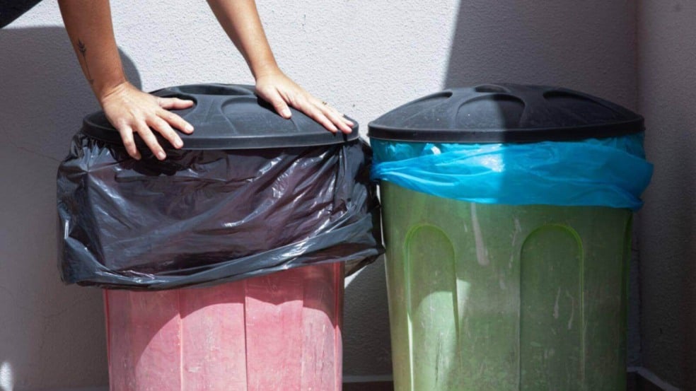 Pessoa fechando lata da lixo