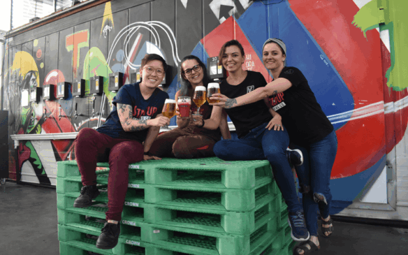 Da esquerda para direita, Marjorie Inove, Bianca Barbarini, Juliana Behr e Aline Tiene, segurando copos de cervejas