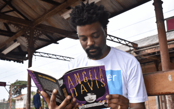 Vinícius Oliveira, de 31 anos, está lendo Angela Davis atualmente. No ano, ele lê, em média, 25 livros. (Foto: Larissa Knupp/Tribuna de Jundiaí)