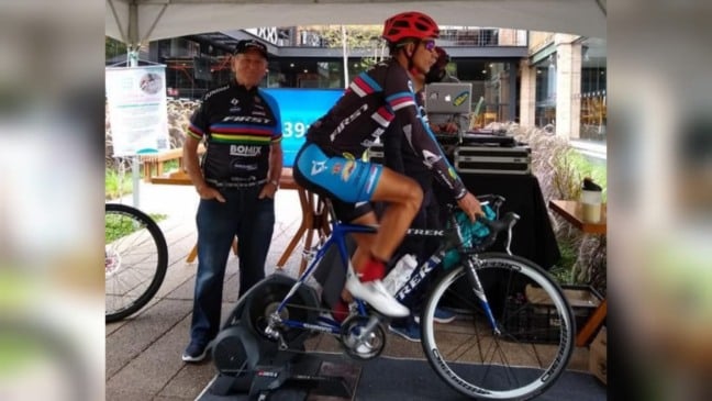 Homem em bicicleta pedalando em rolo de treinamento