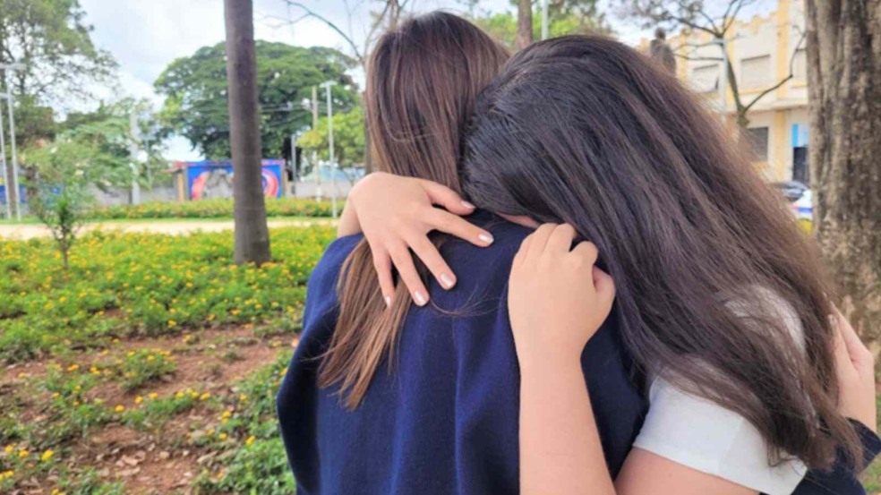 Duas meninas angustiadas se abraçando.