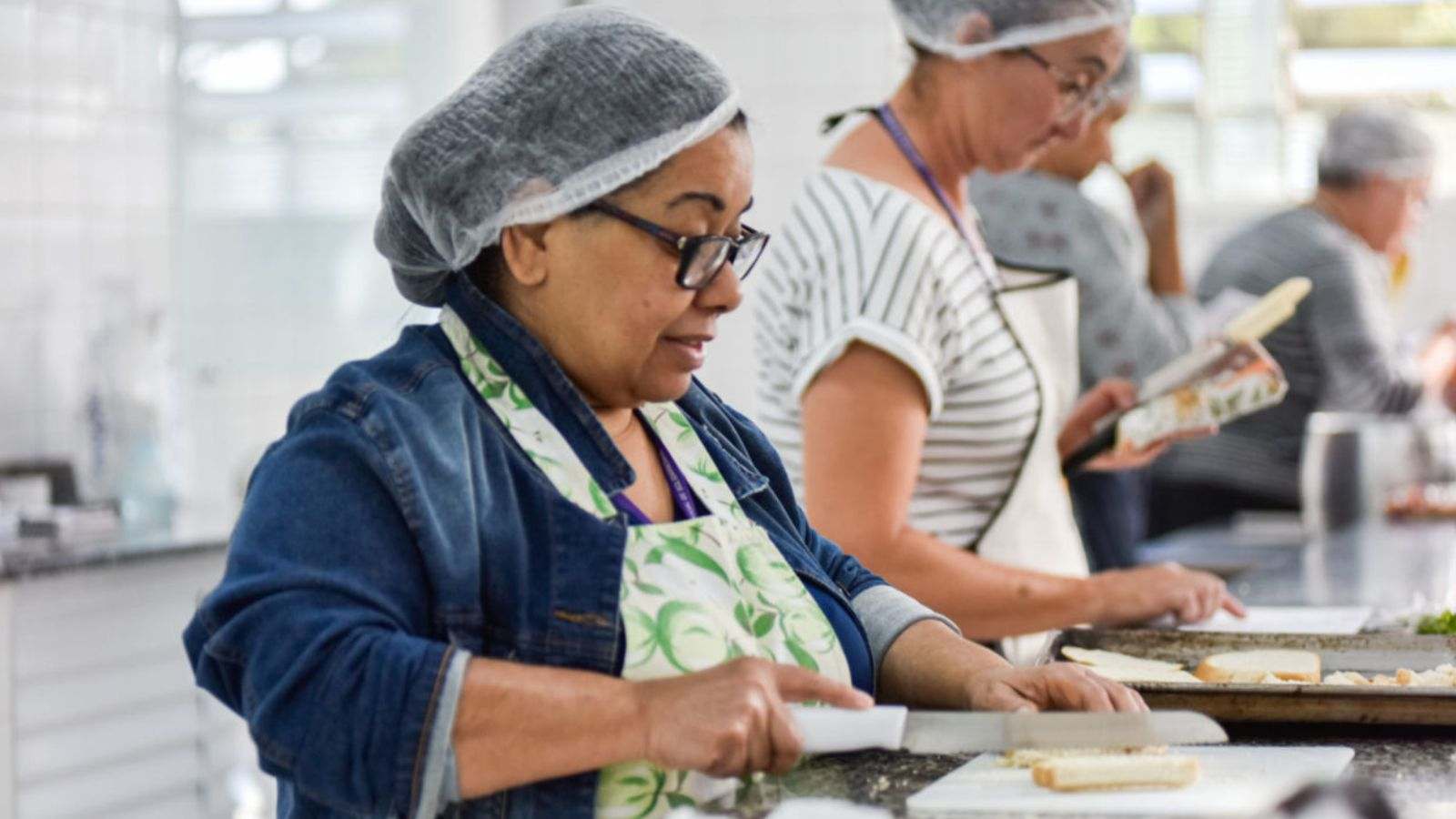 Mulheres em aula de panificação.
