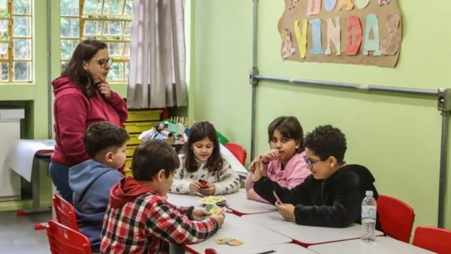 Professora com alunos em sala de aula.