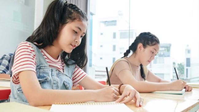 Alunas escrevendo em sala de aula