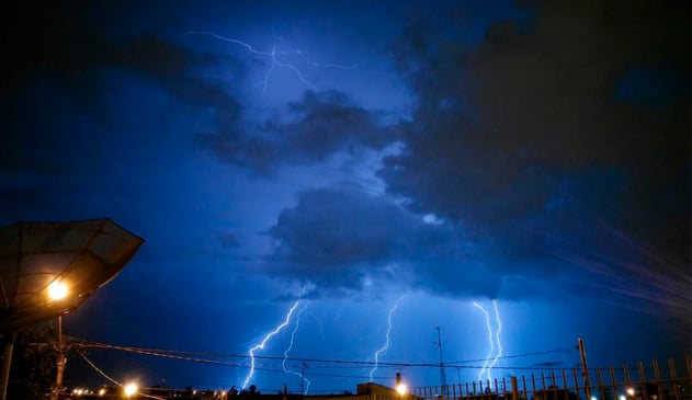 Relâmpagos em céu noturno azulado