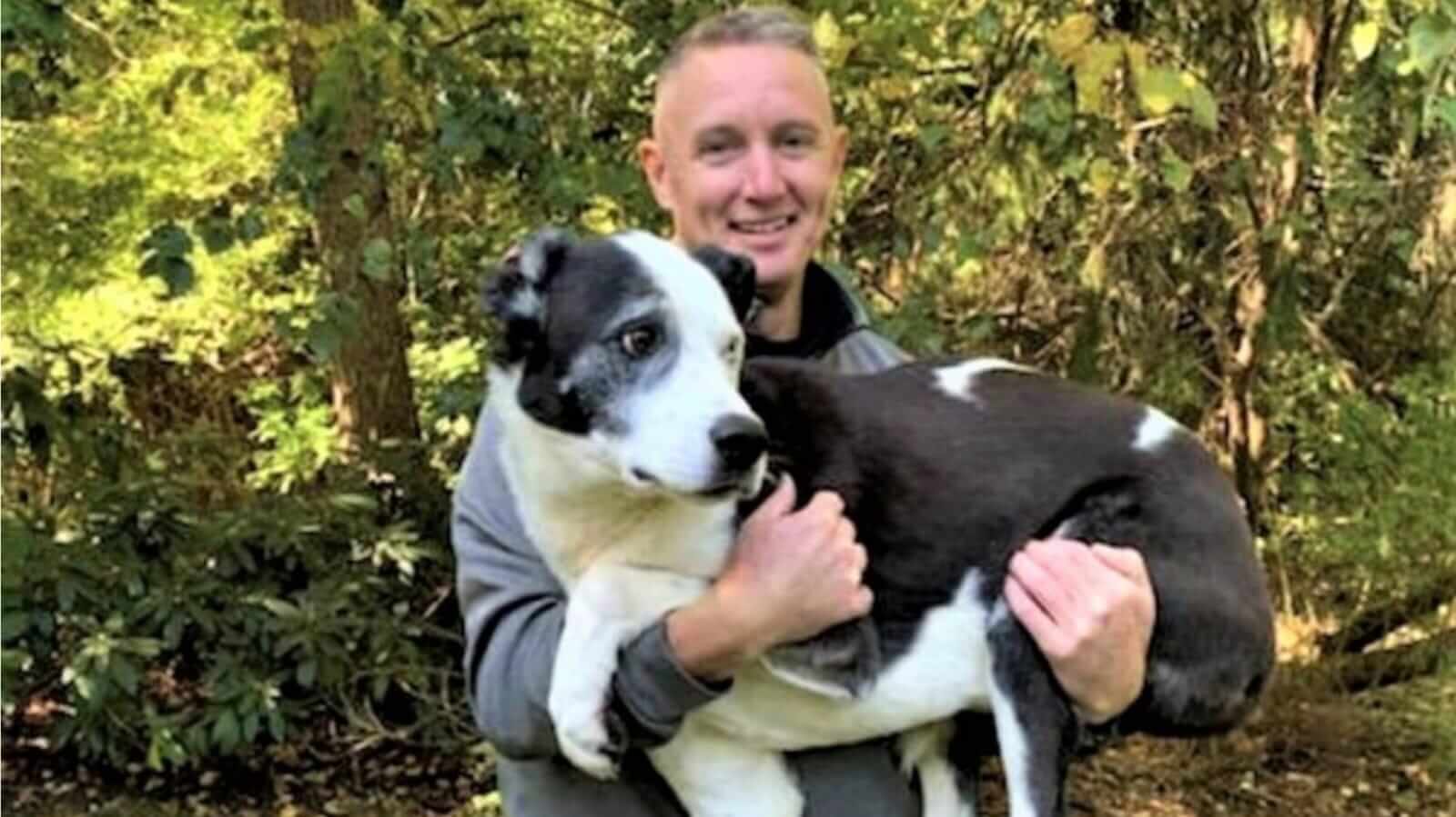 Homem segurando cachorro no colo