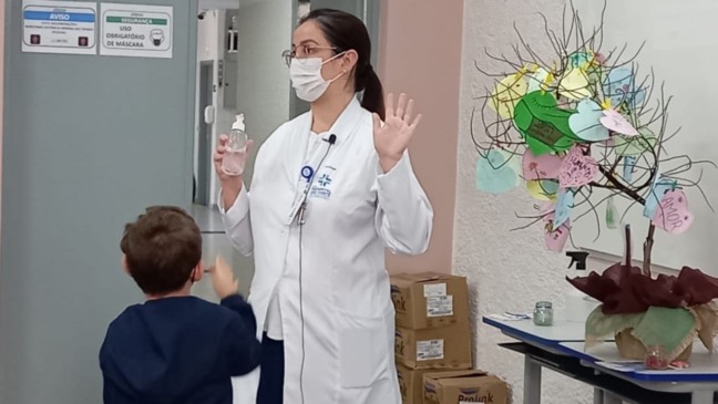 Profissional da saúde com aluno da Escola Padre Anchieta, em Jundiaí