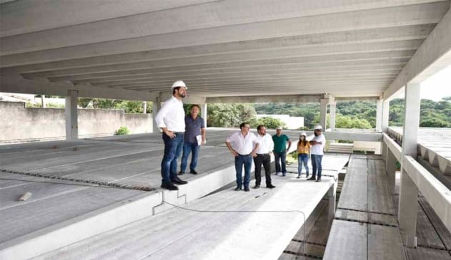 prefeito de jundiaí e funcionários vistoriam obra de nova escola municipal. prefeito e funcionários utilizam capacete de obras. eles estão dentro de um pavimento de blocos de concreto