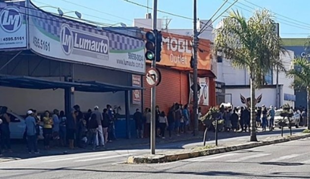 Foto de fila de pessoas em agência bancária
