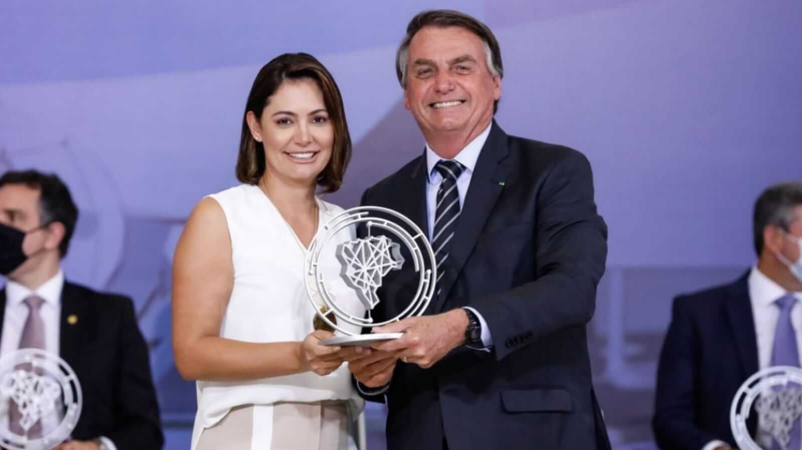 Michelle e Jair Bolsonaro com prêmio nas mãos