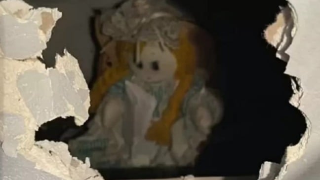 Boneca dentro de parede