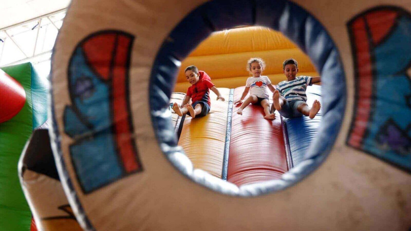 Crianças brincando em escorregador inflável na Festa da Uva