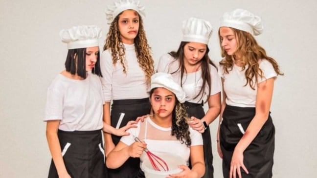 Cinco meninas com roupas de confeiteiras