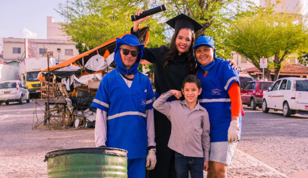 garis com filha formanda, vestindo beca, e filho pequeno a frente