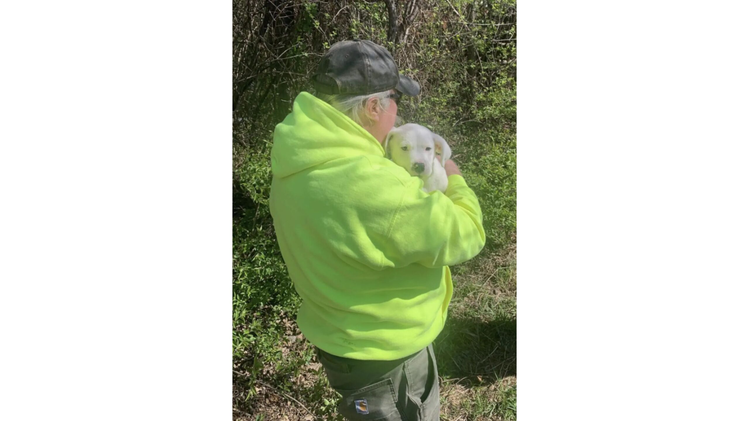 Homem segurando filhote de cachorro branco