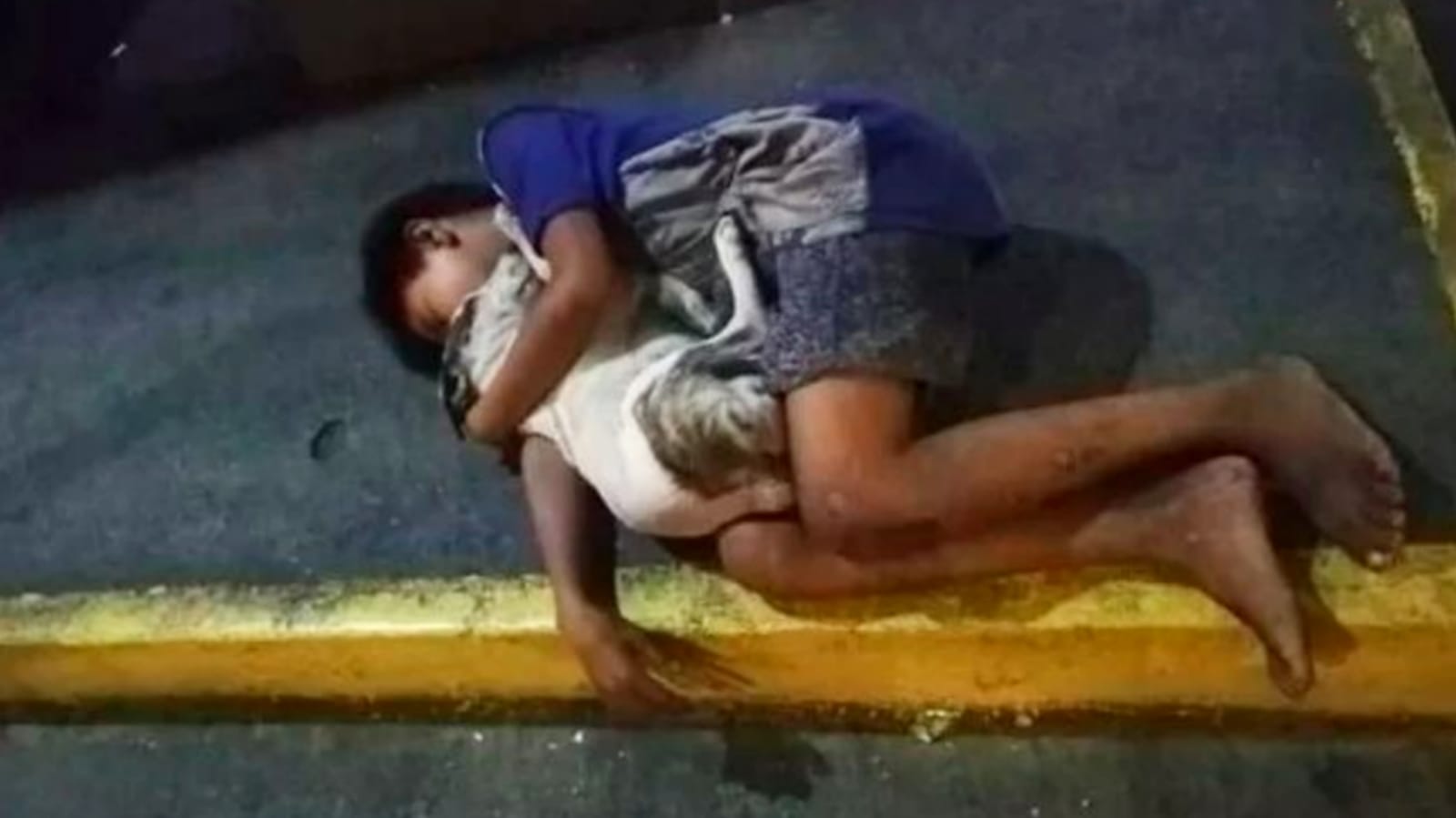 Foto de menino dormindo na rua abraçado com seu cachorrinho