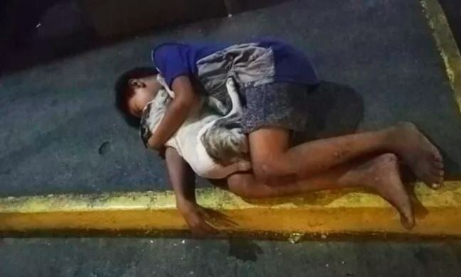 Foto de menino dormindo na rua abraçado com seu cachorrinho