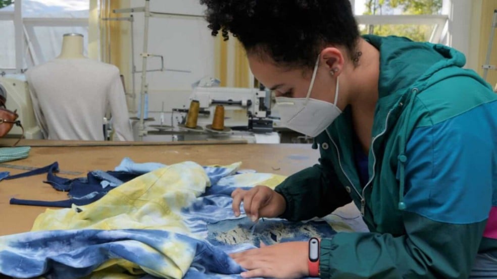 Mulher customizando tecido Mulher customizando tecido