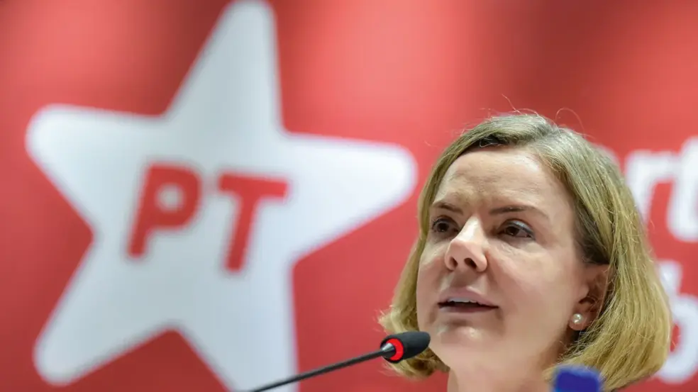 Gleisi Hoffmann, líder do PT, falando em frente a um painel do partido, sobre a eleição de Maduro na Venezuela.