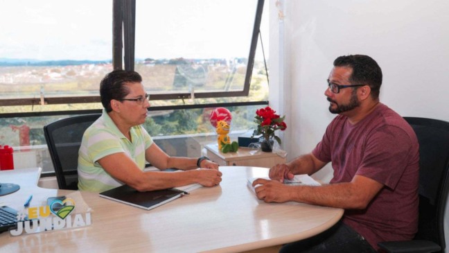 Mulher, à esquerda, conversando com homem, à direita.
