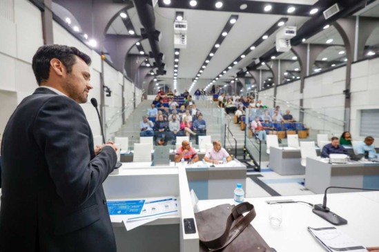 Gestor discursa em audiência pública na câmara municipal, apresentando projetos e interagindo com a comunidade.