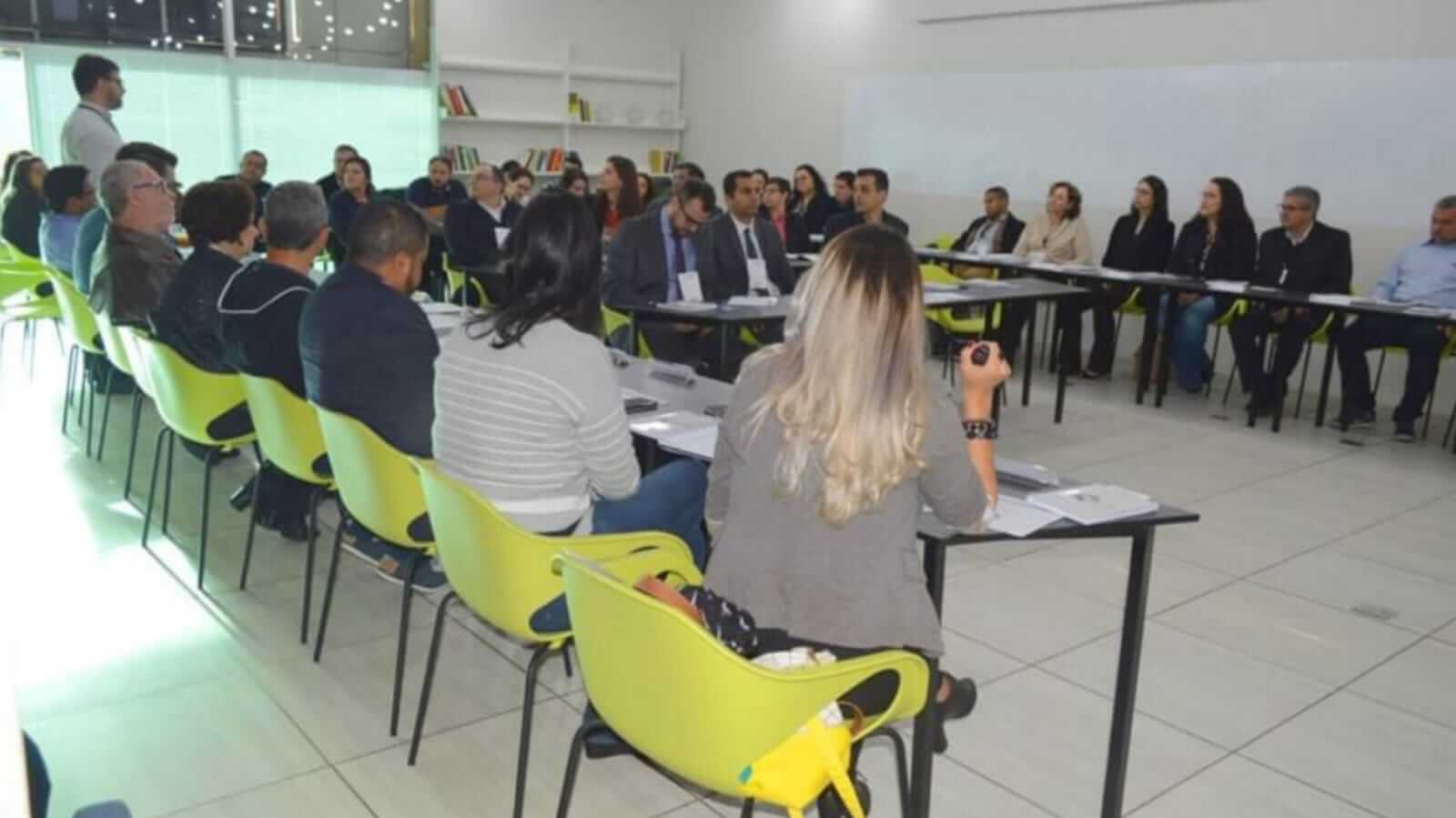 Pessoas em reunião sentadas em cadeiras verdes