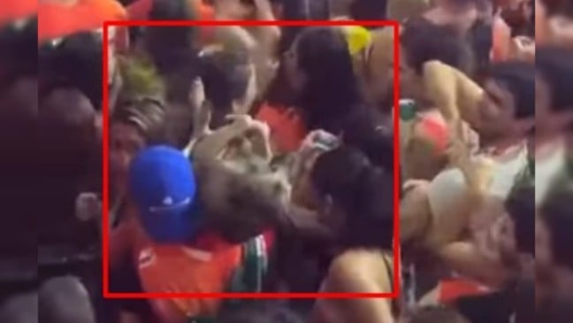 Homem carrega cachorro ferido em bloco de rua