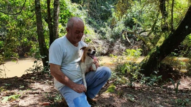 Homem com cachorro no colo