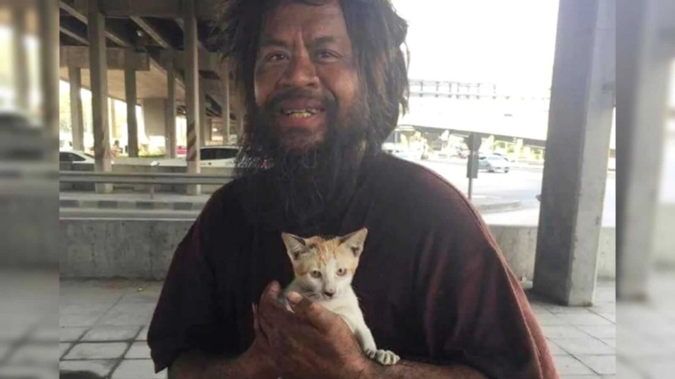 Homem sem-teto segurando gatinho