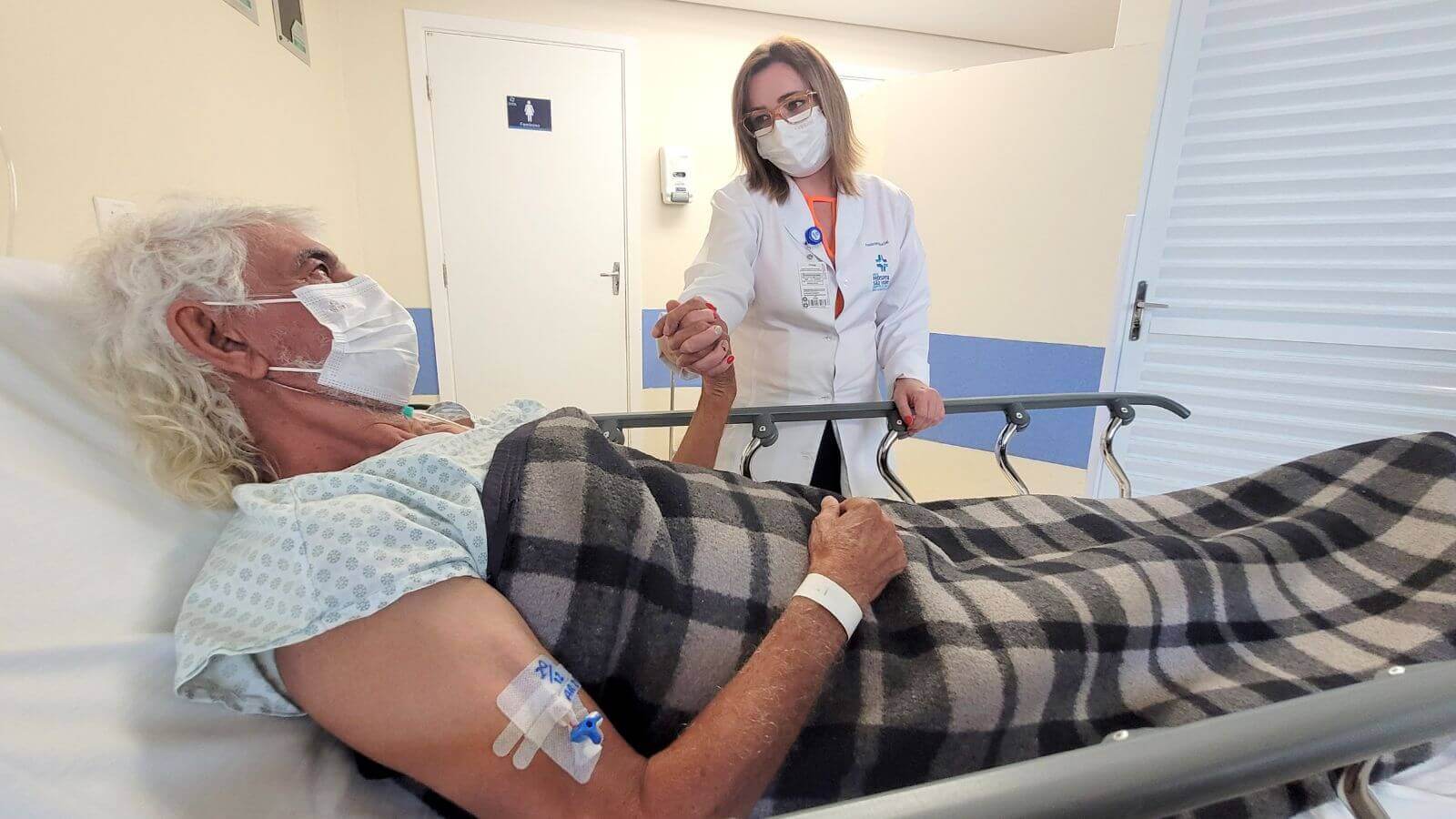 Assistente Social segurando mão de paciente