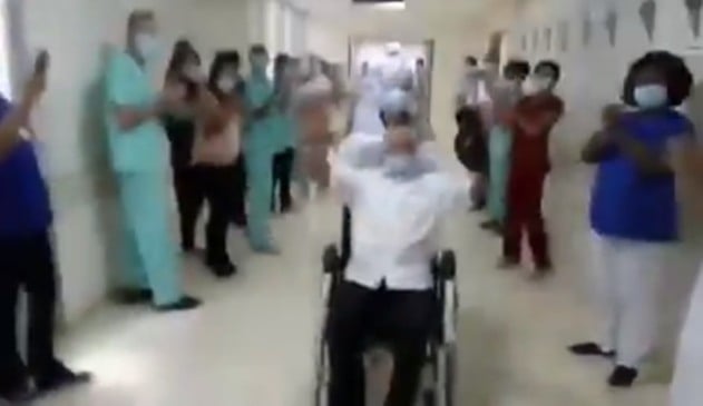 Foto de idoso com braços levantados em cadeira de rodas