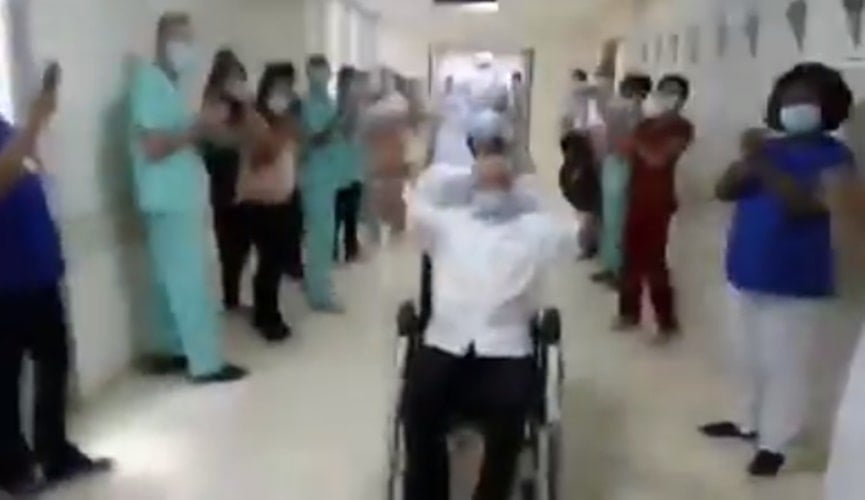 Foto de idoso com braços levantados em cadeira de rodas