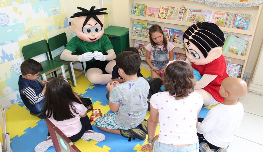 Mônica e Cebolinha da Turma da Mônica sentados em roda de crianças com câncer Mônica e Cebolinha da Turma da Mônica sentados em roda de crianças com câncer