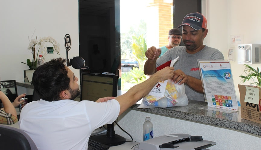 Foto de caminhoneiro retirando kit em posto