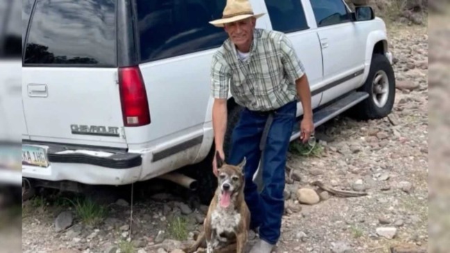 Homem e cachorro na frente de um carro branco