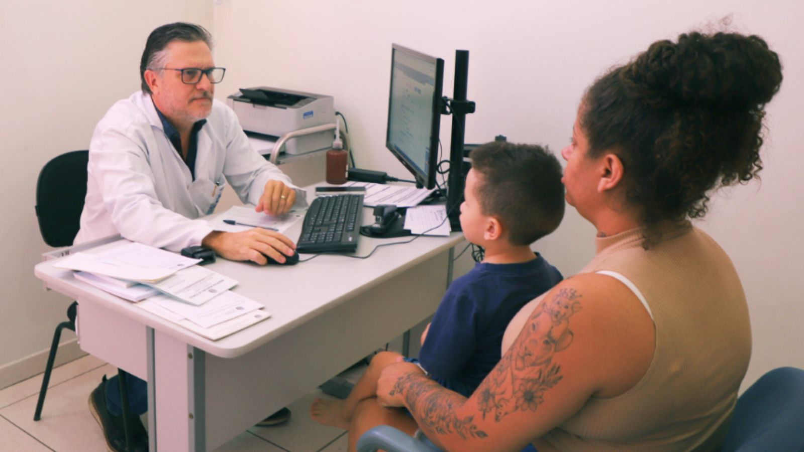 Mulher com sua filhos em consulta de neuropediatra
