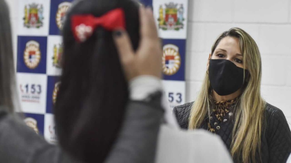 Mulher em frente a adolescente, com imagem desfocada