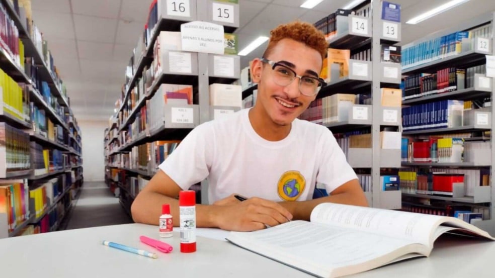 Jovem sentado em biblioteca