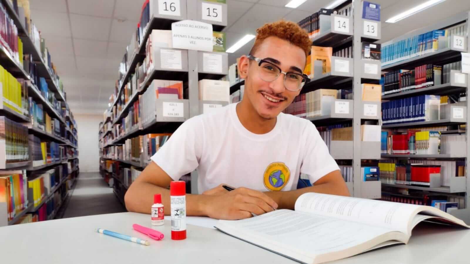Jovem sentado em biblioteca