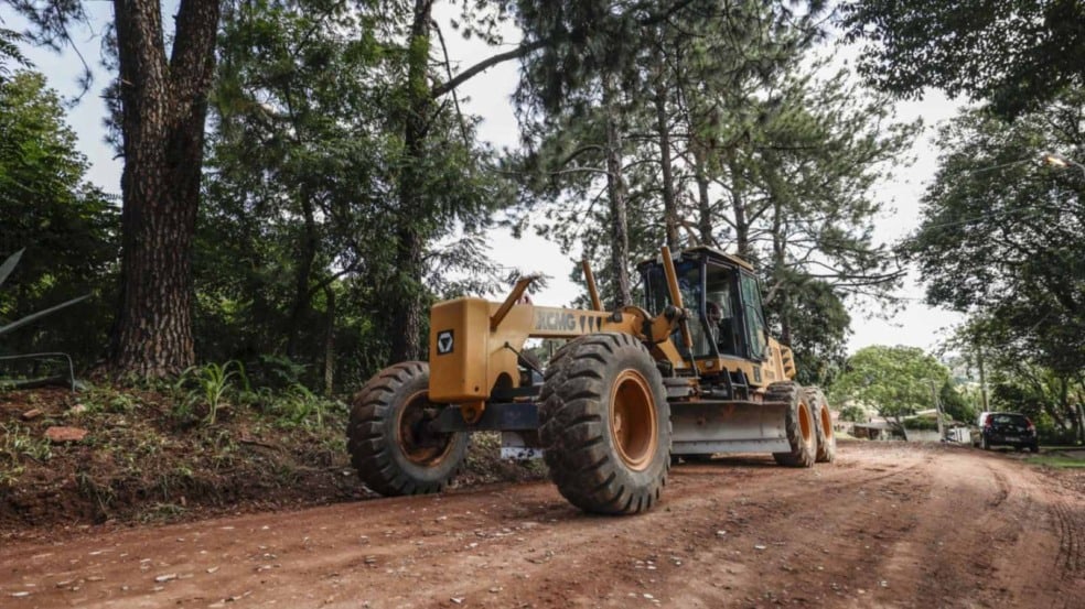 Trator fazendo a manutenção da estrada de terra