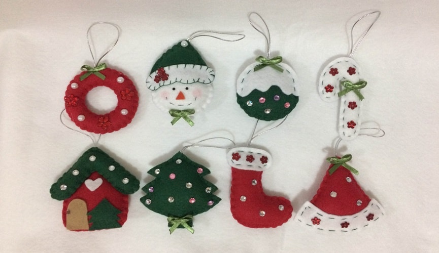 Foto de enfeites natalinos: guirlanda, boneco de neve, bolas, meia, casa, papai noel e chapéu feitos em feltros. Foto de enfeites natalinos: guirlanda, boneco de neve, bolas, meia, casa, papai noel e chapéu feitos em feltros.