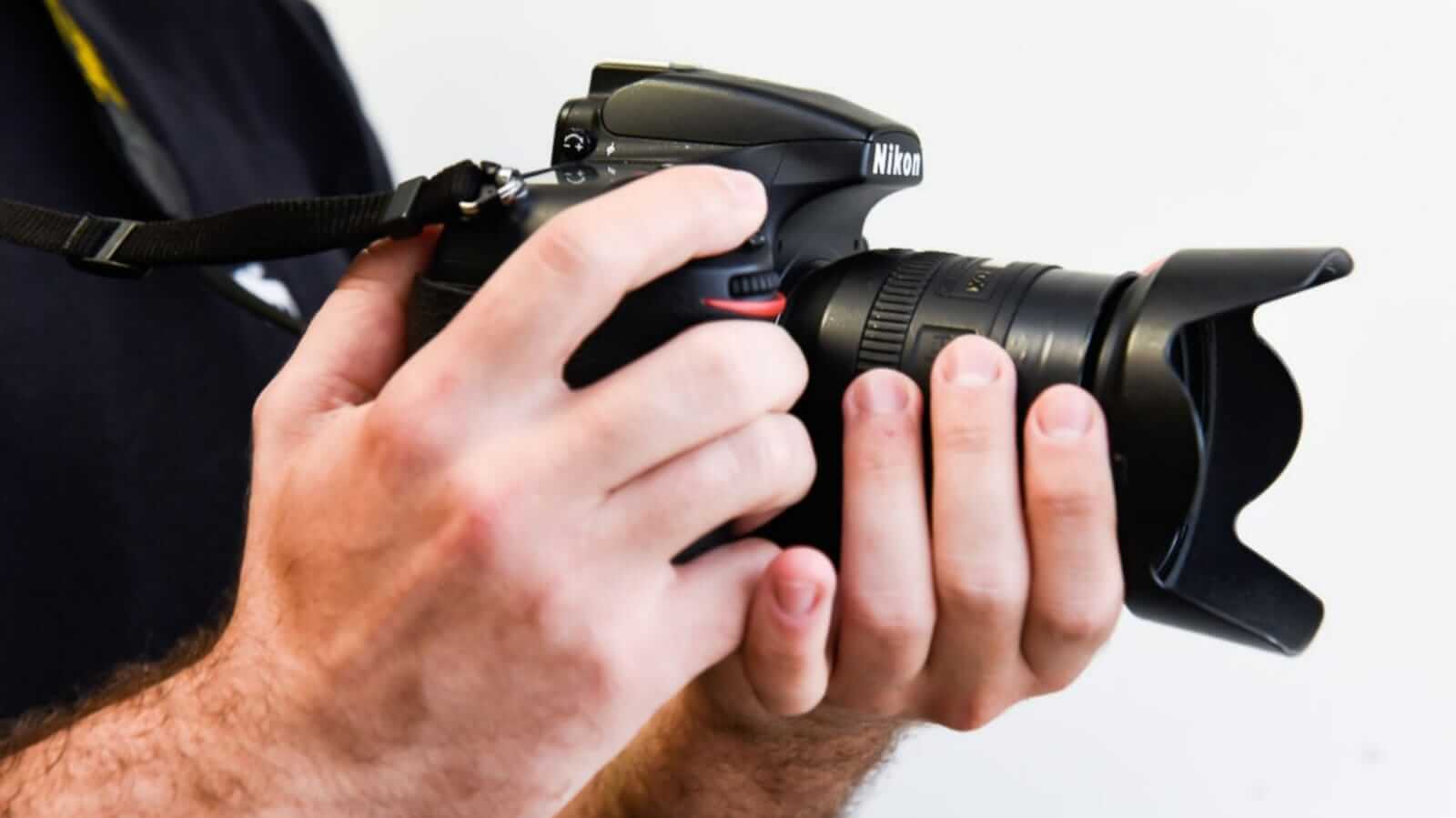 Pessoa segurando câmera fotográfica