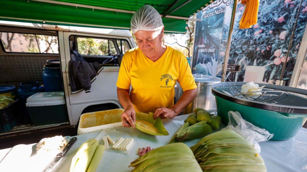 Mulher preparando uma pamonha