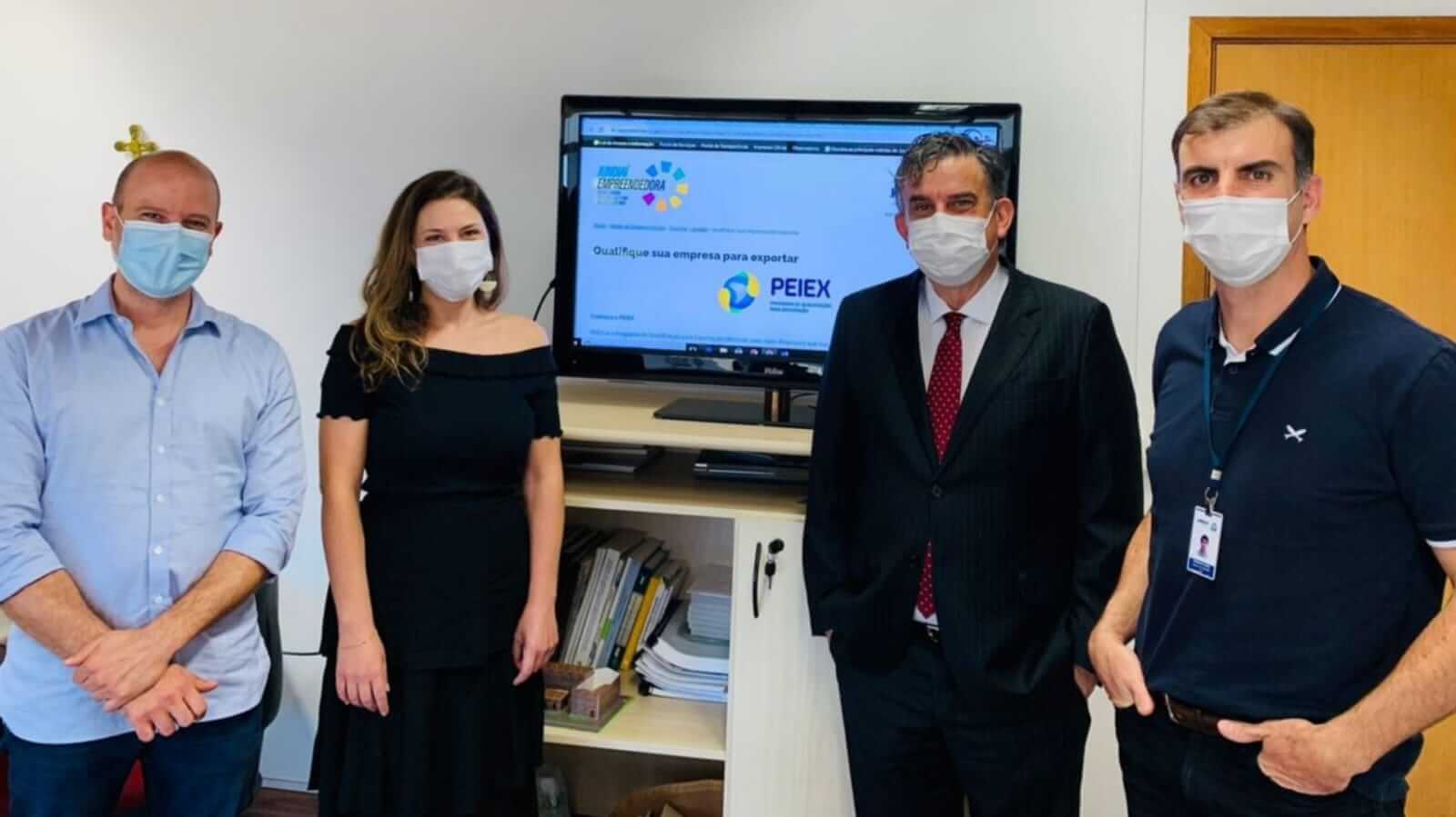 gestores e assessora em frente à TV