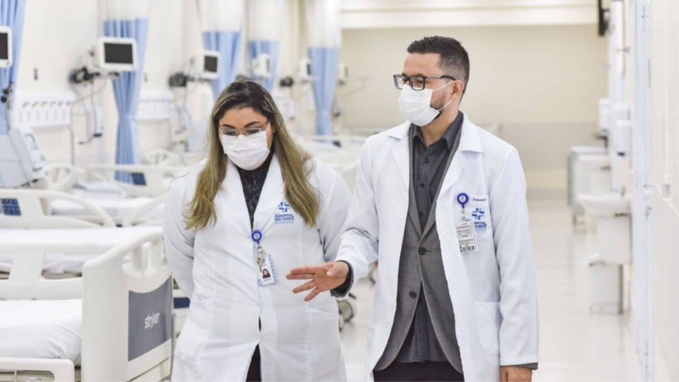 Médicos em hospital com leitos vazios