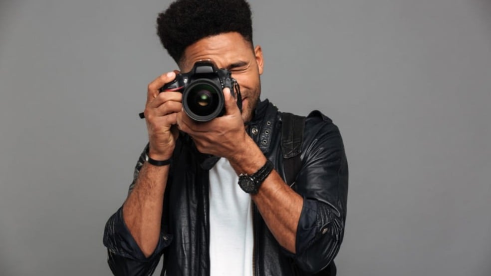 Homem segurando uma câmera fotográfica